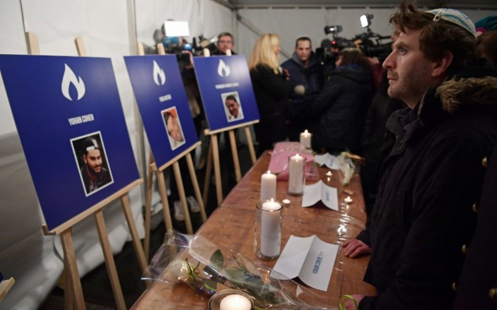 Un homme se tient debout devant des bougies et des photos de Philippe Braham, Yohan Cohen, Yoav Hattab et François Michel Saada tués dans l'attaque mortelle contre le supermarché Hyper Cacher en 2015, lors d'une cérémonie marquant le deuxième anniversaire de l'attaque contre le magasin, à Paris le 9 janvier 2017. (Crédit : AFP PHOTO / CHRISTOPHE ARCHAMBAULT) Un homme se tient debout devant des bougies et des photos de Philippe Braham, Yohan Cohen, Yoav Hattab et François Michel Saada tués dans l'attaque mortelle contre le supermarché Hyper Cacher en 2015, lors d'une cérémonie marquant le deuxième anniversaire de l'attaque contre le magasin, à Paris le 9 janvier 2017. (Crédit : AFP PHOTO / CHRISTOPHE ARCHAMBAULT)