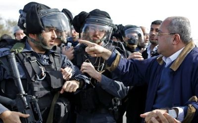 Ahmad Tibi, à droite, député de la Liste arabe unie, face aux policiers dans le village bédouin non reconnu d'Umm al-Hiran, dans le désert du Néguev, le 18 janvier 2017. (Crédit : Ahmad Gharabli/AFP)