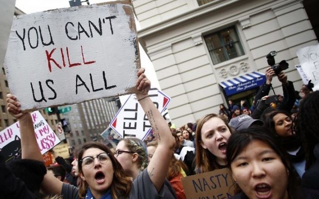 Des manifestantes entourent un char de la parade en provoquant des partisans de Trump lors de la Marche des femmes du 21 janvier 2017 à Washington (Crédit : Joshua Lott/AFP)