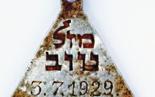 Un pendentif portant les mots hébreux "mazal tov" et la date du 3 juillet 1929 retrouvé dans le camp d'extermination de Sobibor. (Crédit : Yoram Haimi/Autorité israélienne des antiquités) Un pendentif portant les mots hébreux "mazal tov" et la date du 3 juillet 1929 retrouvé dans le camp d'extermination de Sobibor. (Crédit : Yoram Haimi/Autorité israélienne des antiquités)