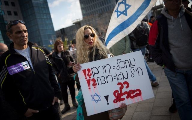 Des soutiens d'Elor Azaria, jugé coupable d'homicide, avec un panneau "terroriste = victime ?! soldat protecteur = assassin ?!" devant la cour militaire de la Kirya à Tel Aviv, le 4 janvier 2017. (Crédit : Miriam Alster/Flash90)