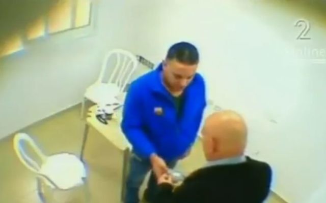 Le député Basel Ghattas remet visiblement un paquet au prisonnier palestinien Walid Daka dans une vidéo diffusée le 23 janvier 2017. (Crédit : capture d'écran Deuxième chaîne)