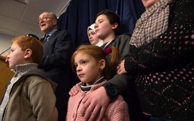 Le sénateur américain Chuck Schumer , ici avec des réfugiés, œuvre pour annuler le décret de Trump, interdisant temporairement l'immigration aux États-Unis de réfugiés et des certains voyageurs musulmans, lors d'un conférence de presse le 29 janvier 2017. (Crédit : AFP PHOTO/ Bryan R. Smith)