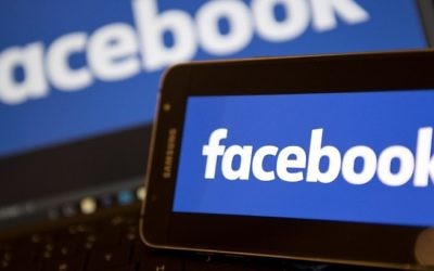 Une photo prise le 21 novembre 2016 montrant des logos Facebook sur les écrans d'un smartphone (à droite) et sur un ordinateur portable, dans le centre de Londres (Crédit : AFP)