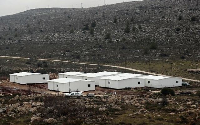 Construction de nouvelles maisons préfabriquées en Cisjordanie, entre l'avant-poste d'Amona (au fond) et l'implantation d'Ofra, au nord de Ramallah, le 31 janvier 2017. (Crédit : Thomas Coex/AFP)