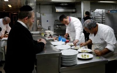 Lors de l'édition 2017, le chef français Laurent Delarbre (au centre) aide à préparer un menu casher, sous la supervision d'un rabbin (à gauche), lors de la semaine consacrée à la cuisine française, "So French, so Food au restaurant "La Vache sur le toit"", le 8 février 2017 à Jérusalem (Crédit : AFP PHOTO / THOMAS COEX)