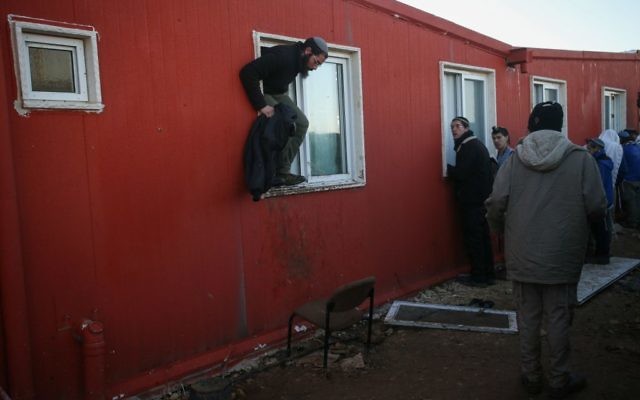 Des manifestants entourent la synagogue d'Amona, au 2e jour de l'évacuation de l'avant-poste de Cisjordanie, le 2 février 2017. (Crédit : Yonatan Sindel/Flash90)