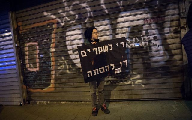 Un manifestant avec une pancarte "Assez de mensonges, assez d'incitations à la haine" pendant une manifestation contre le traitement réservé à la minorité arabe par le gouvernement israélien, à Tel Aviv, le 4 février 2017. (Crédit : Miriam Alster/Flash90) Un manifestant avec une pancarte "Assez de mensonges, assez d'incitations à la haine" pendant une manifestation contre le traitement réservé à la minorité arabe par le gouvernement israélien, à Tel Aviv, le 4 février 2017. (Crédit : Miriam Alster/Flash90)