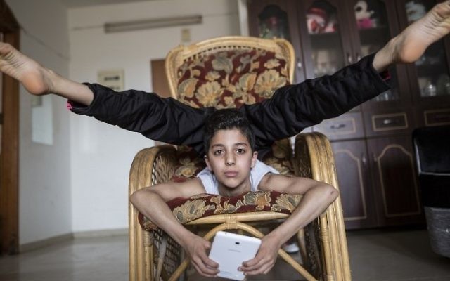 Une photo prise le 28 avril 2016 de Mohammed al-Sheikh, alors âgé de douze ans, l'adolescent palestinien montrant ses talents de contorsionniste à son domicile dans la ville de Gaza (Crédit ; AFP PHOTO / MAHMUD HAMS) Une photo prise le 28 avril 2016 de Mohammed al-Sheikh, alors âgé de douze ans, l'adolescent palestinien montrant ses talents de contorsionniste à son domicile dans la ville de Gaza (Crédit ; AFP PHOTO / MAHMUD HAMS)