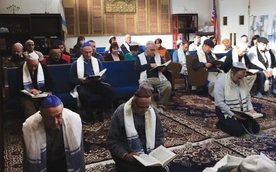 C'est une coutume pour les Juifs karaïtes de prier à genoux sur le sol, comme on le voit ici dans le sanctuaire de la congrégation  Bnai Israel à Daly City, en Californie. (Autorisation des Juifs Karaïtes des Etats unis via JTA)