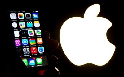 Un iPhone à côté du logo Apple (Crédit : AFP PHOTO / Philippe HUGUEN)