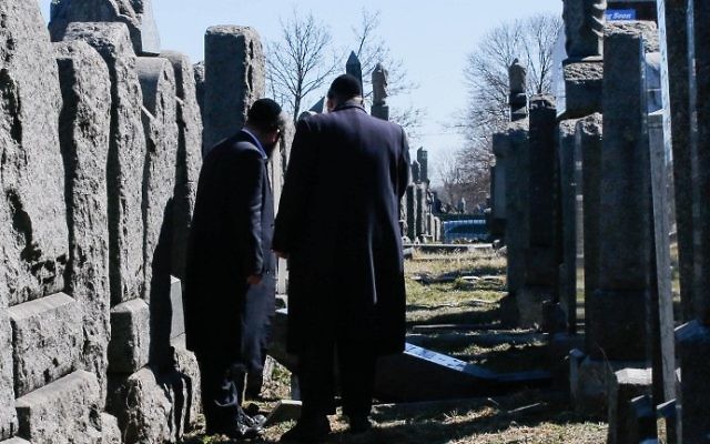 Les membres de la communauté juive inspectent les pierres tombales qui ont été renversées dans le Washington Cemetery de New York, dans le quartier de Brooklyn, le 5 mars 2017 ( Crédit : AFP PHOTO / EDUARDO MUNOZ ALVAREZ) Les membres de la communauté juive inspectent les pierres tombales qui ont été renversées dans le Washington Cemetery de New York, dans le quartier de Brooklyn, le 5 mars 2017 ( Crédit : AFP PHOTO / EDUARDO MUNOZ ALVAREZ)
