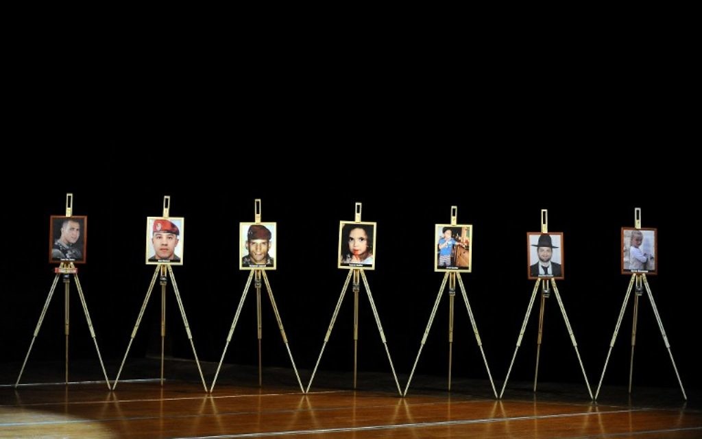 Les portraits des sept victimes - Imad Ibn Ziaten, Abel Chennouf, Mohamed Legouad, Gabriel Sandler, Aryeh Sandler, Myriam Monsonégo et Jonathan Sandler - de Mohamed Merah pendant une cérémonie de commémoration organisée par le CRIF à Toulouse, le 19 mars 2014. (Crédit : Rémy Gabalda/AFP)