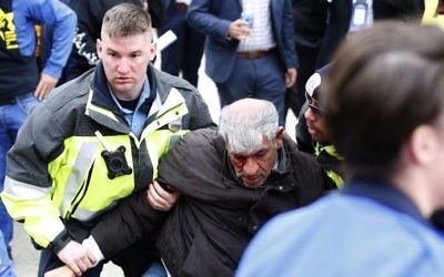 La police sauve un manifestant pendant des affrontements entre manifestants contre l'AIPAC et ses partisans à Washington, D.C., le 26 mars 2017. (Crédit : Andrew Biraj/AFP)