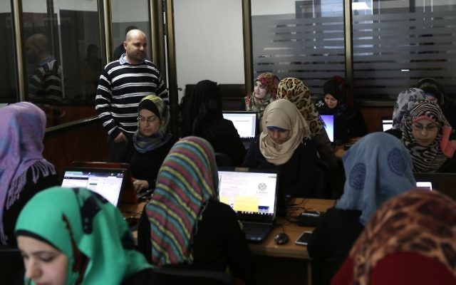 Des employées entrent des données dans les bureaux d'Unit One à Gaza (Crédit : Mahmud Hams / AFP)