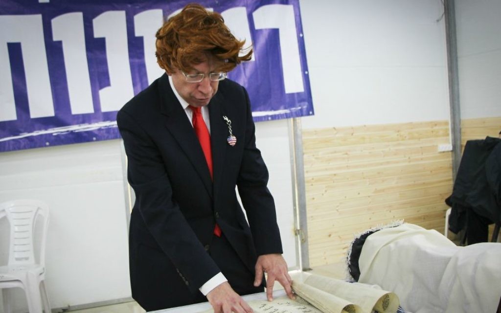 Un homme déguisé en Donald Trump lit le Livre d'Esther dans la synagogue de Shmurat Oz Vegaon, dans le Gush Etzion, pour la fête de Pourim, le 12 mars 2017. (Crédit : Gershon Elinson/Flash90)