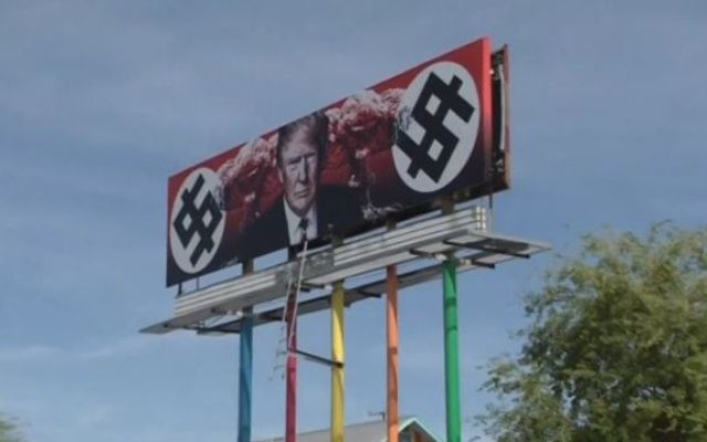 Une affiche créée par une artiste représentant le président américain Donald Trump avec des dollars en forme de croix gammée et des champignons nucléaires à Phoenix, Arizona, le 18 mars 2017. (Crédit : capture d'écran Reuters) Une affiche créée par une artiste représentant le président américain Donald Trump avec des dollars en forme de croix gammée et des champignons nucléaires à Phoenix, Arizona, le 18 mars 2017. (Crédit : capture d'écran Reuters)