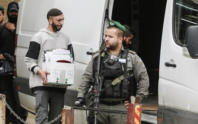 Les forces de l'ordre israéliennes dans le village d'al-Ram en Cisjordanie, durant la fermeture des bureaux aui auraient été utilisés par l'AP pour suivre les transactions immobilières entre Palestiniens et juifs, le 14 mars 2017. (Crédit : AFP PHOTO/Ahmad Gharabli) Les forces de l'ordre israéliennes dans le village d'al-Ram en Cisjordanie, durant la fermeture des bureaux aui auraient été utilisés par l'AP pour suivre les transactions immobilières entre Palestiniens et juifs, le 14 mars 2017. (Crédit : AFP PHOTO/Ahmad Gharabli)