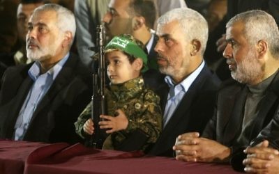 Yahya Sinwar, 2e à droite, nouveau chef du Hamas à Gaza, et Ismail Haniyeh, à gauche, près du fils de Mazen Foqaha, cadre terroriste du groupe, pendant ses funérailles, à Gaza Ville, le 27 mars 2017. (Crédit : Mahmud Hams/AFP)