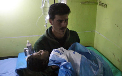 Un enfant syrien inconscient transporté à l'hôpital de Khan Sheikhun, une ville tenue par les rebelles de la province d'Idleb, après une attaque au gaz toxique, le 4 avril 2017. (Crédit : Omar Haj Kadour/AFP)