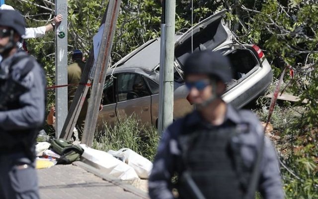 Les forces de sécurité israéliennes sur le site d'une attaque à la voiture bélier, près de l'implantation d'Ofra, en Cisjordanie, le 6 avril 2017. (Crédit : Thomas Coex/AFP)
