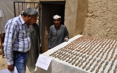 Un archéologue égyptien, à droite, devant les artefacts découverts dans une tombe de 3 500 ans dans la nécropole de Draa Abul Nagaa, proche de Louxor, en Egypte, le 18 avril 2017. (Crédit : AFP/Stringer)