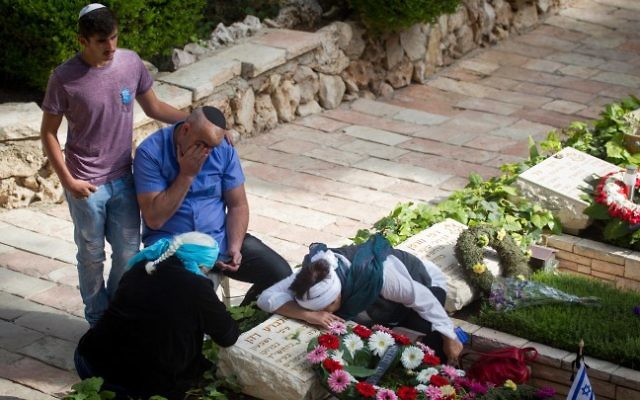 Des Israéliens en deuil près des tombes des soldats qui ont perdu la vie lors des combats au cimetière militaire du mont Hertzl de Jérusalem pour Yom HaZikaron, le 11 mai 2016. (Crédit : Miriam Alster/Flash90)