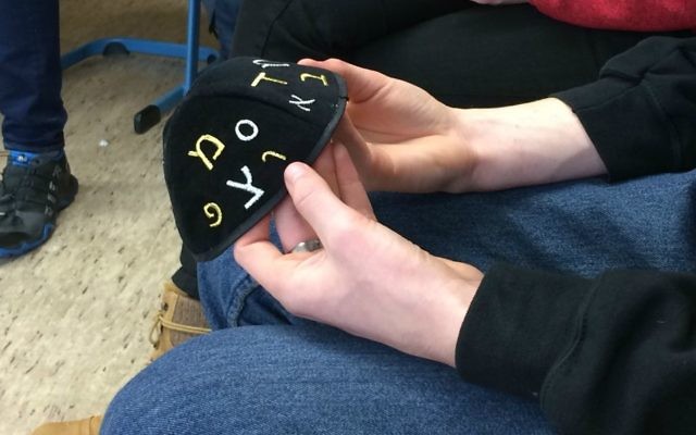 Un étudiant du Technisches Berufskolleg tient une kippa pendant une visite de 'Louez un Juif' à Solingen, en Allemagne, en novembre 2016 (Crédit : Kate Brady/DW.com)