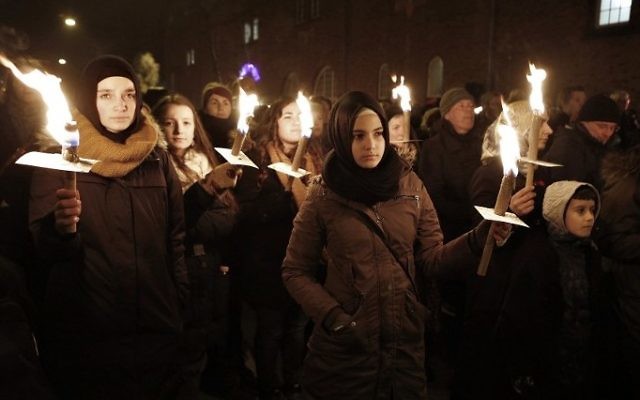Des gens tiennent des bougies durant un service de commémoration à la mémoire des victimes tuées par un homme armé à Copenhague, le 16 février 2015 (Crédit :: Bax Lindhardt/Scanpix Denmark/AFP)