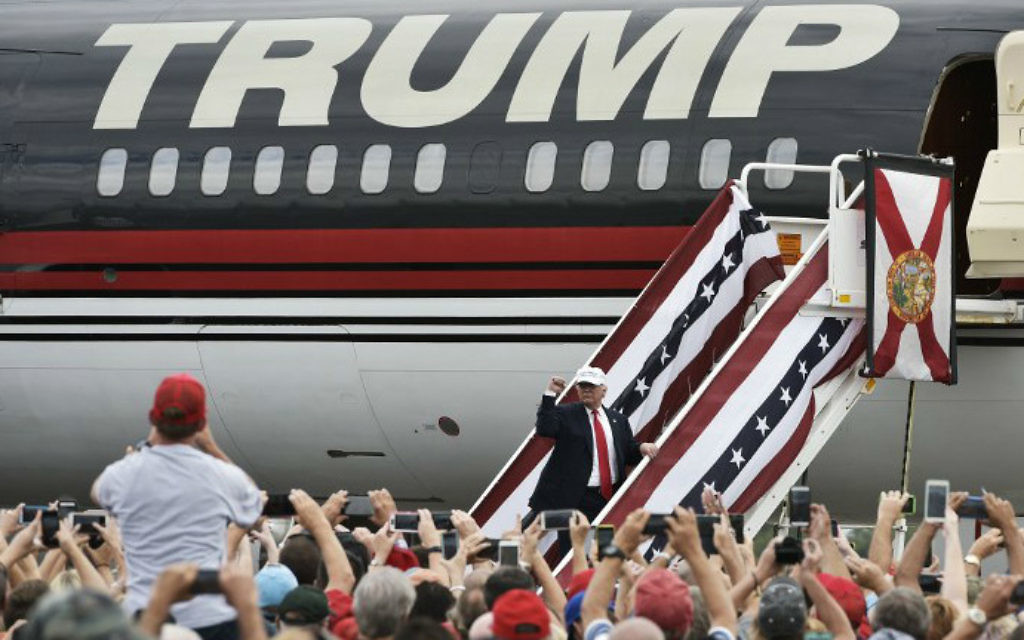 Alors candidat à la présidence, Donald Trump salue ses partisans avant d'entrer dans son avion après un rassemblement à l'aéroport régional Linder de Lakeland en Floride, le 12 octobre 2016 (Crédit : Mandel Ngan/AFP) Alors candidat à la présidence, Donald Trump salue ses partisans avant d'entrer dans son avion après un rassemblement à l'aéroport régional Linder de Lakeland en Floride, le 12 octobre 2016 (Crédit : Mandel Ngan/AFP)