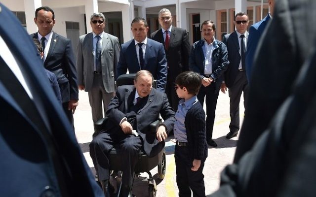 Le président algérien Abdelaziz Bouteflika avec son neveu après avoir voté aux élections législatives, à Alger, le 4 mai 2017. (Crédit : Ryad Kramdi/AFP)