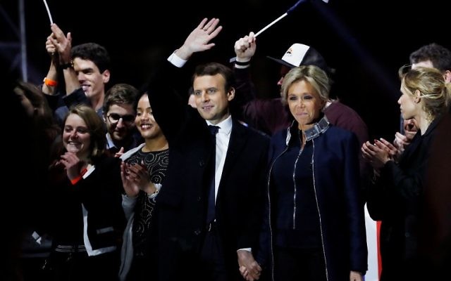 Emmanuel Macron, élu à la présidence de la République française, au centre, et son épouse Brigitte, devant la pyramide du Louvre, le 7 mai 2017. (Crédit : Patrick Kovarik/AFP)