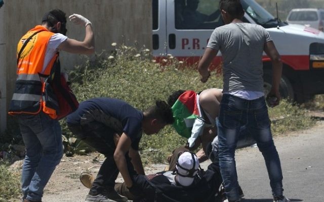 Les Palestiniens soignant 'un manifestant blessé lors d'affrontements avec l'armée israélienne dans le village de Beit Furik, à l'est de Naplouse, le 12 mai 2017 (Crédit : Jaafar Ashtiyeh / AFP)