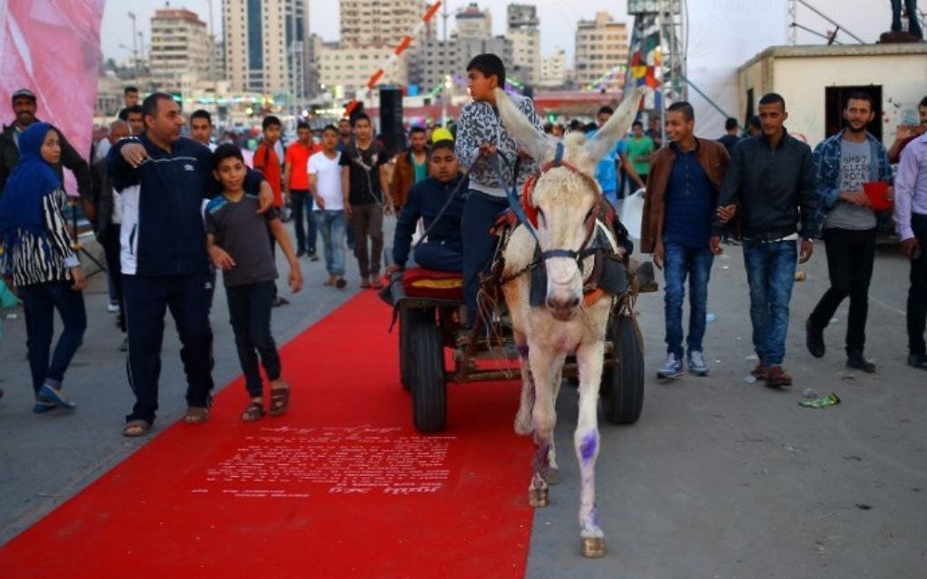 Un Palestinien sur le tapis rouge sur lequel est inscrit le texte de la déclaration Balfour, à Gaza Ville, le 12 mai 2017. (Crédit : Mohammed Abedi/AFP) Un Palestinien sur le tapis rouge sur lequel est inscrit le texte de la déclaration Balfour, à Gaza Ville, le 12 mai 2017. (Crédit : Mohammed Abedi/AFP)