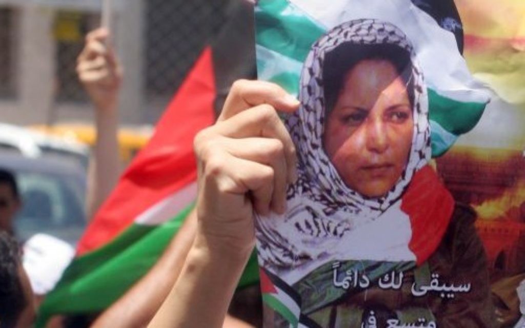 Des Palestiniens avec des affiches et des T-shirts représentant Dalal Mughrabi, une terroriste du Fatah responsable du massacre de la route côtière en 1978, qui a tué 38 Israéliens dont 13 enfants, pendant une manifestation à Ramallah, le 16 juillet 2008. (Crédit : Issam Rimawi/Flash90)