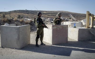 Des soldats à un poste de contrôle près de la ville de Hebron en Cisjordanie, le 2 juillet 2016. (Crédit : Wisam Hashlamoun / Flash90) Des soldats à un poste de contrôle près de la ville de Hebron en Cisjordanie, le 2 juillet 2016. (Crédit : Wisam Hashlamoun / Flash90)