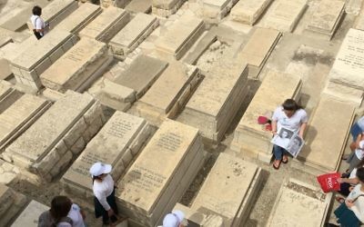 Un groupe de lycéens écoute des histoires sur les soldats israéliens tombés au combat, sur le Mont des Oliviers, durant Yom Hazikaron 2017. (Crédit : Jessica Steinberg/Times of Israel)Mont des Olivi