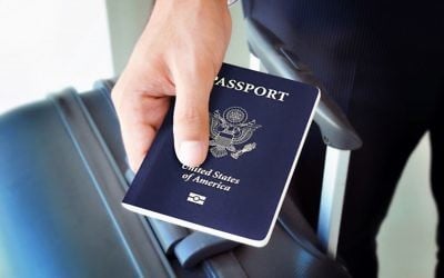 Homme tenant un passeport américain (Crédit : Shutterstock)