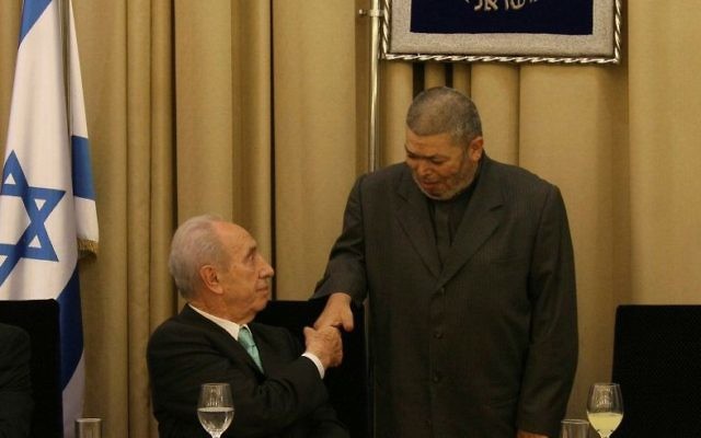 Feu le président israélien Shimon Peres échange une poignée de main avec Sheikh Abdullah Nimr Darwish, à droite, pendant un repas de l'Iftar à la résidence présidentielle de Jérusalem, le 9 septembre 2008 (Crédit : Anna Kaplan/Flash90) Feu le président israélien Shimon Peres échange une poignée de main avec Sheikh Abdullah Nimr Darwish, à droite, pendant un repas de l'Iftar à la résidence présidentielle de Jérusalem, le 9 septembre 2008 (Crédit : Anna Kaplan/Flash90)