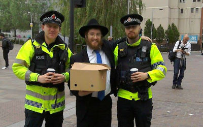 Le rabbin Shneur Cohen distribue des boissons chaudes et des viennoiseries à la police qui travaille sur les lieux de l'attentat qui a frappé Manchester, au Royaume-Uni, le 23 mai 2017. (Crédit : Chabad of Manchester City Center) Le rabbin Shneur Cohen distribue des boissons chaudes et des viennoiseries à la police qui travaille sur les lieux de l'attentat qui a frappé Manchester, au Royaume-Uni, le 23 mai 2017. (Crédit : Chabad of Manchester City Center)
