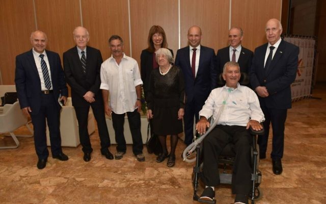 Huit des neufs lauréats du Prix Israël 2017 prennent la pose au Centre de conférences international de Jérusalem, le 2 mai 2017. Depuis la gauche,  Yosef Yarden, Arie Vardi, David Beeri, Nili Cohen (derrière), Agnes Keleti, Naftali Bennett, Zvika Levy (en chaise roulante), et Uri Shaked. Absents : Yehuda Liebes et Malka Margalit. (Crédit : Shlomi Amsalem)