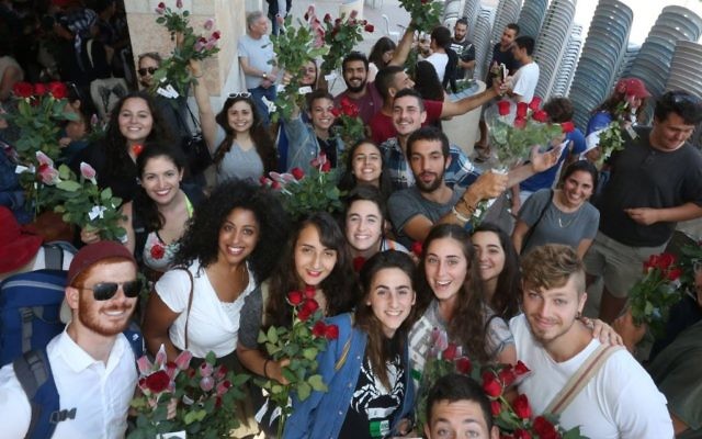 Des militants pour la paix participent à un défilé organisé par Tag Meir avec une distribution de fleurs aux commerçants arabes dans la Vieille ville de Jérusalem, en amont de la parade des drapeaux de la journée de Jérusalem, le 24 mai 2017 (Autorisation). Des militants pour la paix participent à un défilé organisé par Tag Meir avec une distribution de fleurs aux commerçants arabes dans la Vieille ville de Jérusalem, en amont de la parade des drapeaux de la journée de Jérusalem, le 24 mai 2017 (Autorisation).