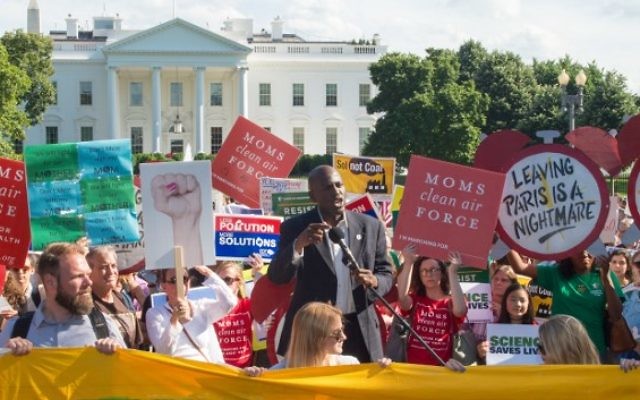 Des manifestants brandissent des pancartes durant une manifestation devant la Maison Blanche à Washington, le 1er juin 2017, s'opposant à la décision du président  Donald Trump de se retirer des accords de Paris sur le climat (Crédit : PAUL J. RICHARDS/AFP PHOTO /)