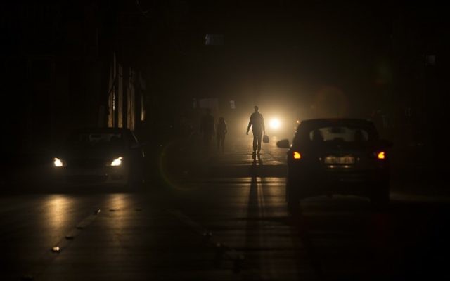 Des Palestiniens dans une rue sombre lors d'une coupure de courant dans le camp de réfugiés d'al-Shati de Gaza, le 11 juin 2017. (Crédit : Mahmud Hams/AFP)