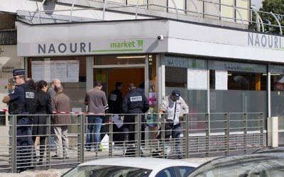 Des policiers enquêtent sur l'explosion d'une bombe dans un supermarché casher de Sarcelles, après que deux hommes masqués on lancé une grenade à l'intérieur du magasin en plein jour, le 19 septembre 2012. (Crédit : Joël Saget/AFP)