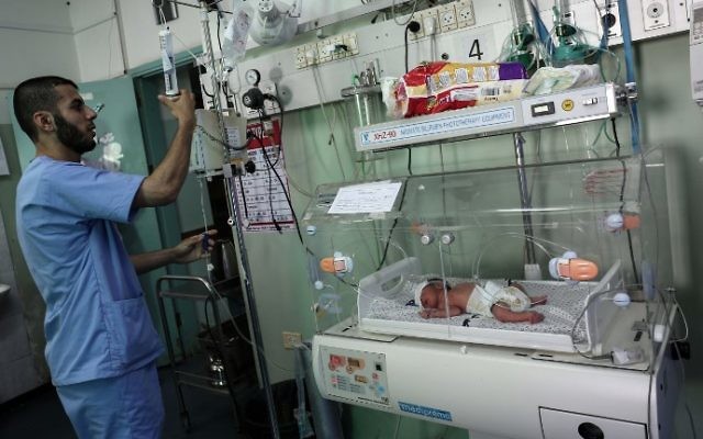 Un infirmier palestinien prenant soin d'un nouveau-né à l'unité de néonatalogie à l'hôpital des Emirats arabes unis à Rafah, dans le sud de la bande de Gaza, le 27 juin 2017. (Crédit : Said Khatib/AFP) Un infirmier palestinien prenant soin d'un nouveau-né à l'unité de néonatalogie à l'hôpital des Emirats arabes unis à Rafah, dans le sud de la bande de Gaza, le 27 juin 2017. (Crédit : Said Khatib/AFP)