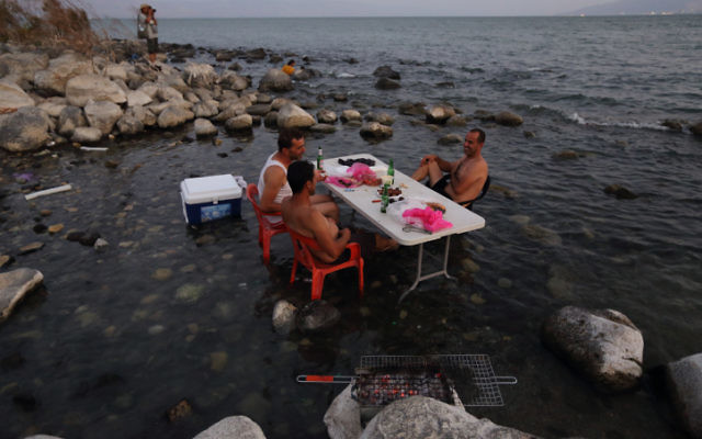 Des Israéliens au lac de Kinneret profitent d'un barbecue dans l'eau, le 18 août 2014 (Crédit : Yaakov Naumi/Flash90) Des Israéliens au lac de Kinneret profitent d'un barbecue dans l'eau, le 18 août 2014 (Crédit : Yaakov Naumi/Flash90)