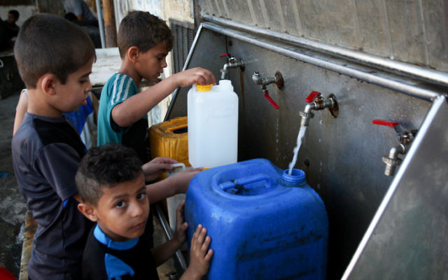 Des enfants palestiniens remplissent des jerrycans avec de l'eau potable provenant de robinets publics dans le sud de la bande de Gaza, le 11 juin 2017 (Crédit : Abed Rahim Khatib / Flash90) Des enfants palestiniens remplissent des jerrycans avec de l'eau potable provenant de robinets publics dans le sud de la bande de Gaza, le 11 juin 2017 (Crédit : Abed Rahim Khatib / Flash90)