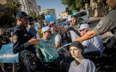 Un militant tentant de s'immoler pendant une manifestation contre la hausse insuffisante de l'allocation handicapé, devant la résidence du Premier ministre à Jérusalem, le 27 juin 2017. (Crédit : Yonatan Sindel/Flash90)