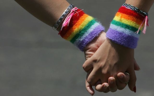 Un couple de lesbiennes se tient la main durant la marche des Fiertés de Tel Aviv le 3 juin 2016 (Crédit : David Silverman/Getty Images via JTA, File)